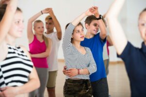 Group of happy french teen dancing salsa in dance studio